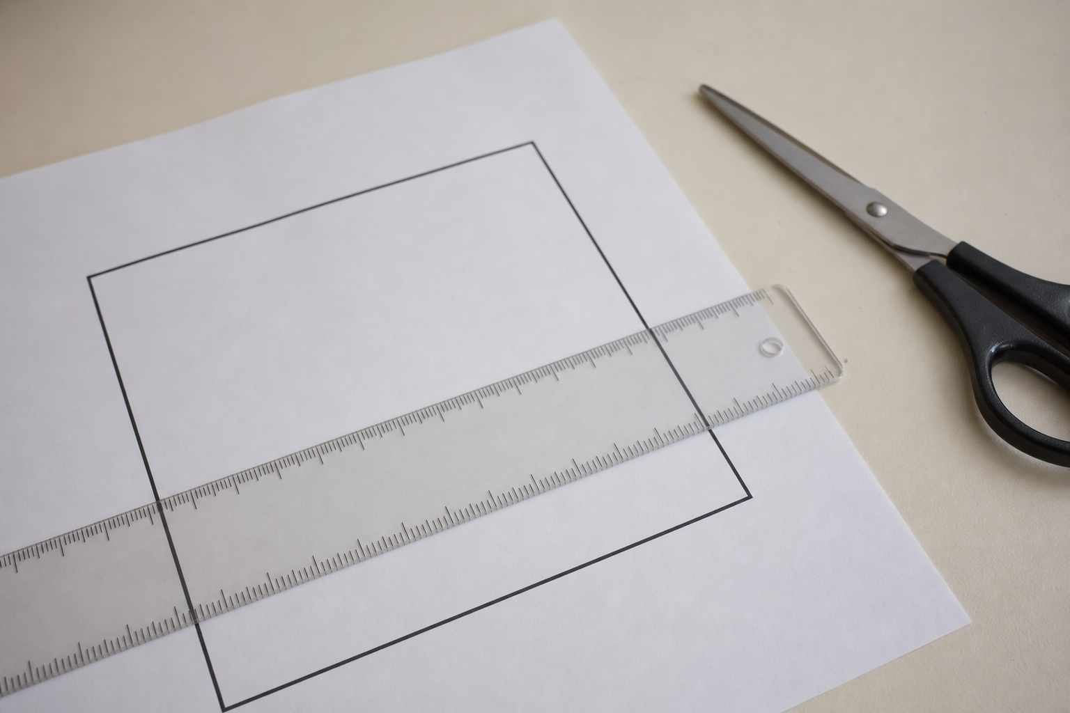 Lineal auf einem ausgedruckten Kontrollquadrat neben einer Schere
